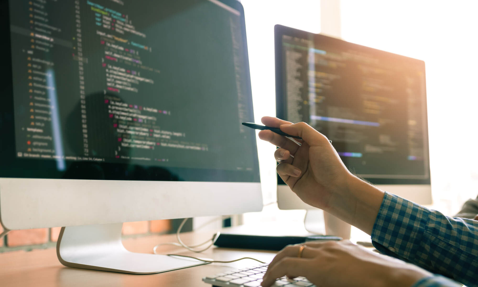technically proficient atlassian contractor working on two monitors using VScode